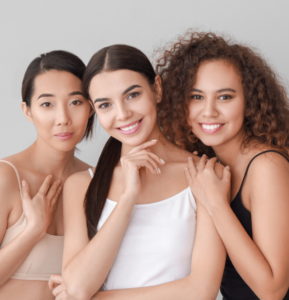 Three women with beautiful skin smile at the camera